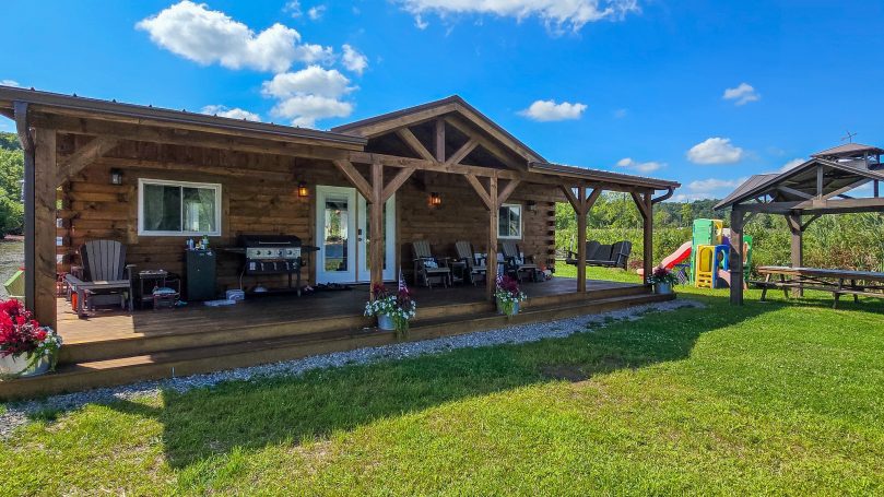 Log cabin on a lake with nice covered front porch.